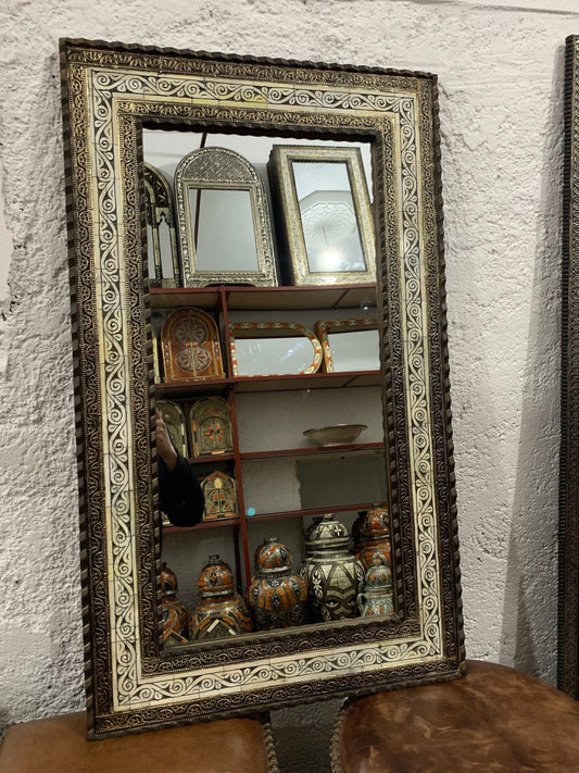 a mirror sitting on top of a wooden table