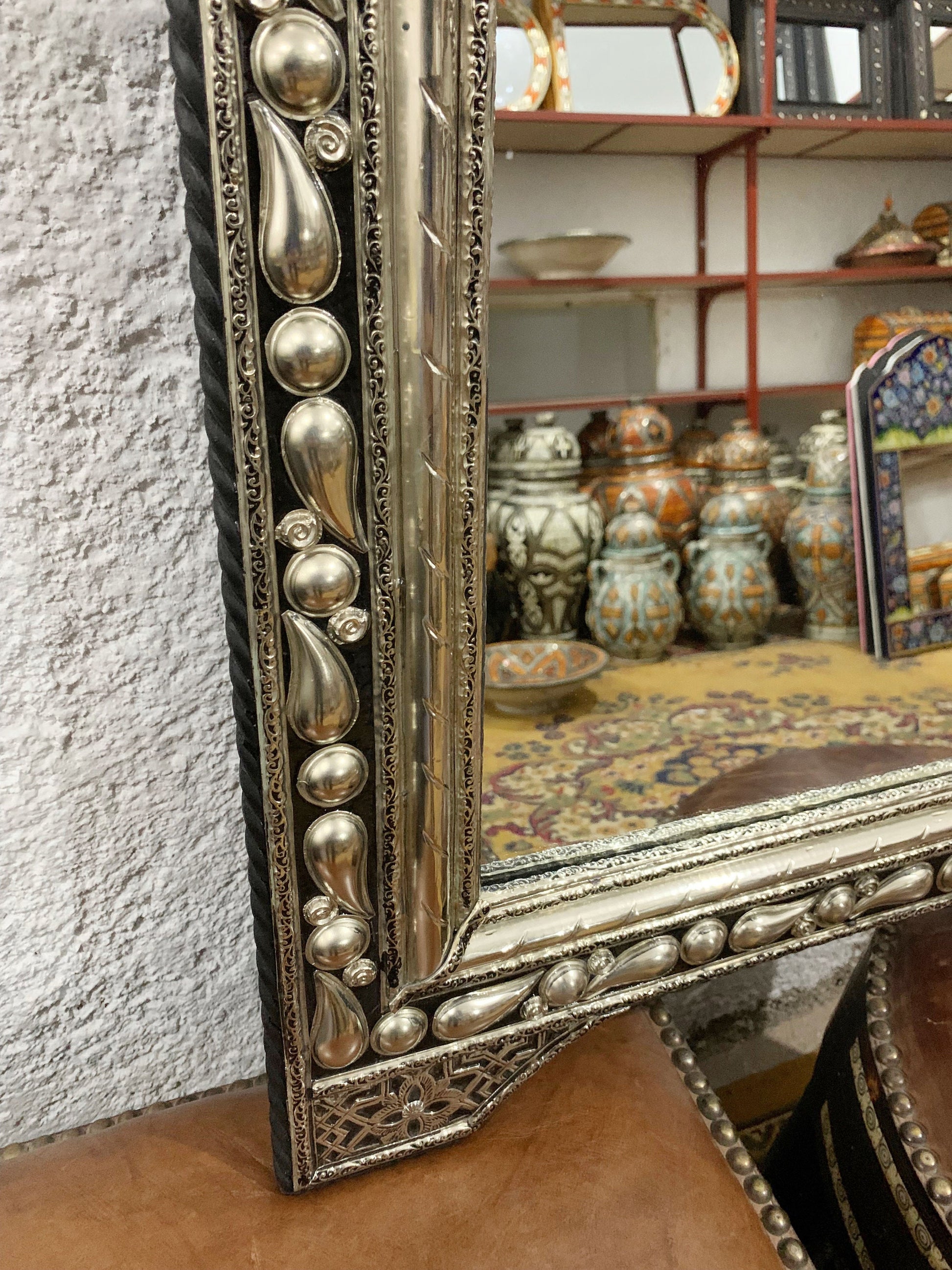 a silver framed mirror sitting on top of a table