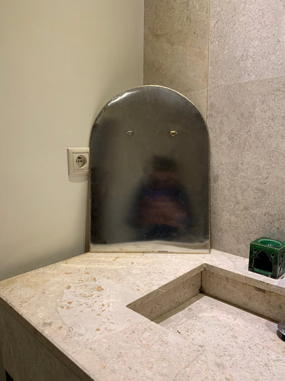 a person is reflected in a mirror in a bathroom