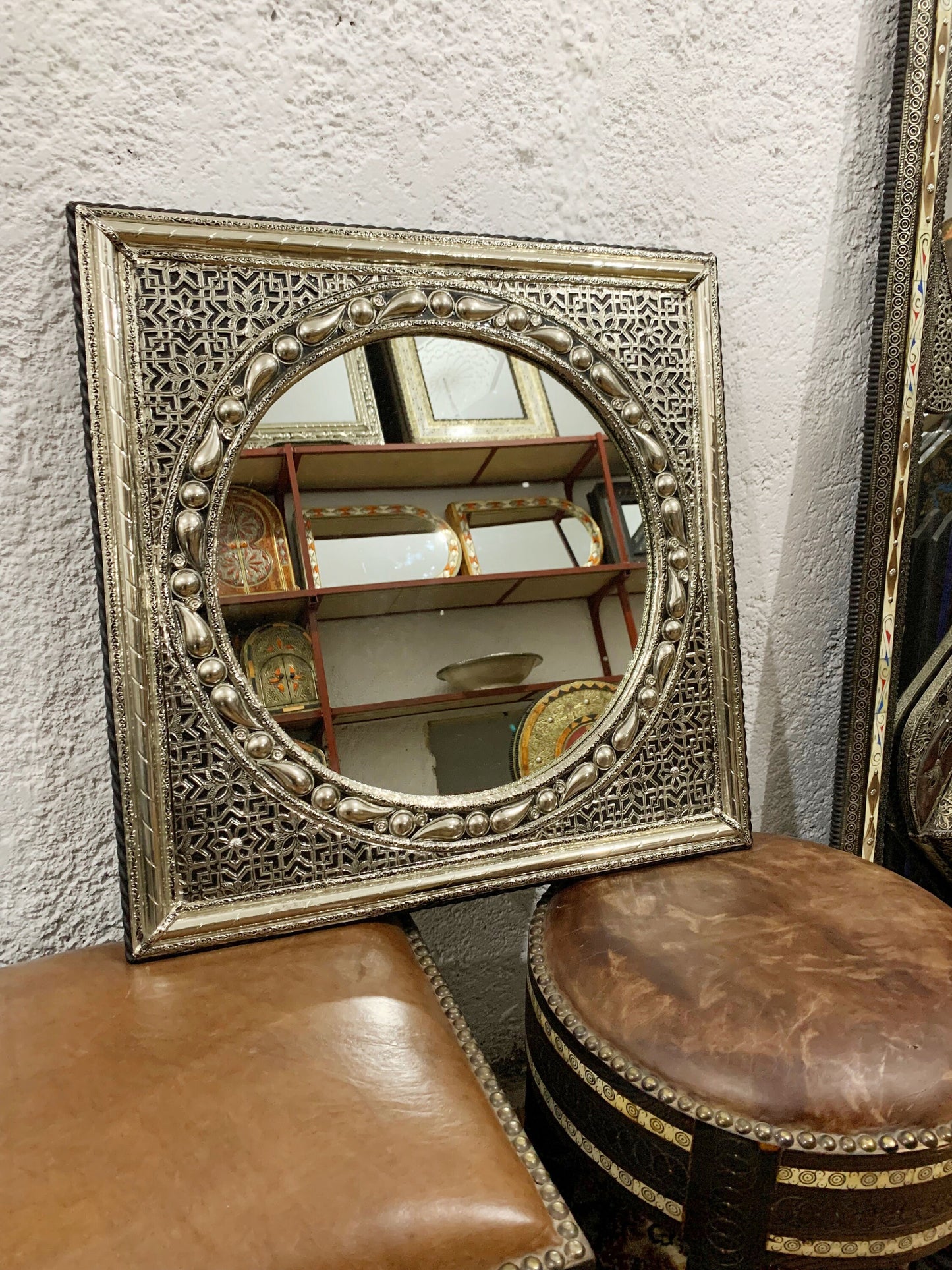 a mirror sitting on top of a table next to a stool