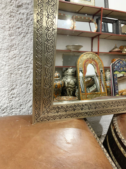 a mirror sitting on top of a brown leather chair