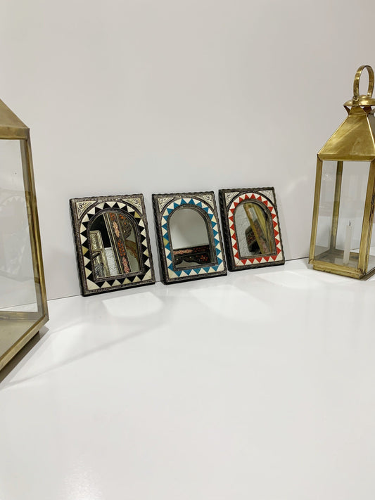 a row of three small mirrors sitting on top of a table