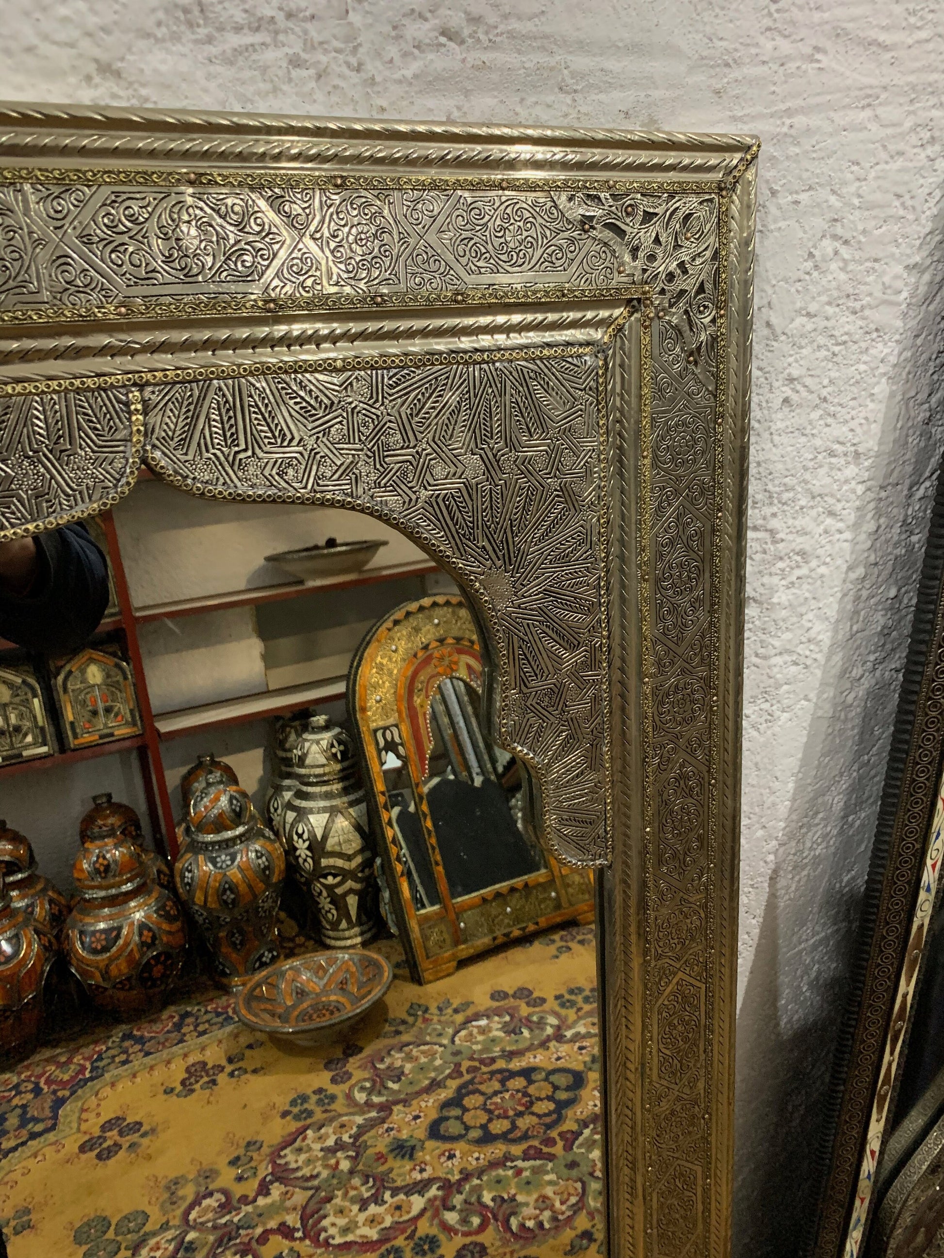 a gold framed mirror sitting on top of a table