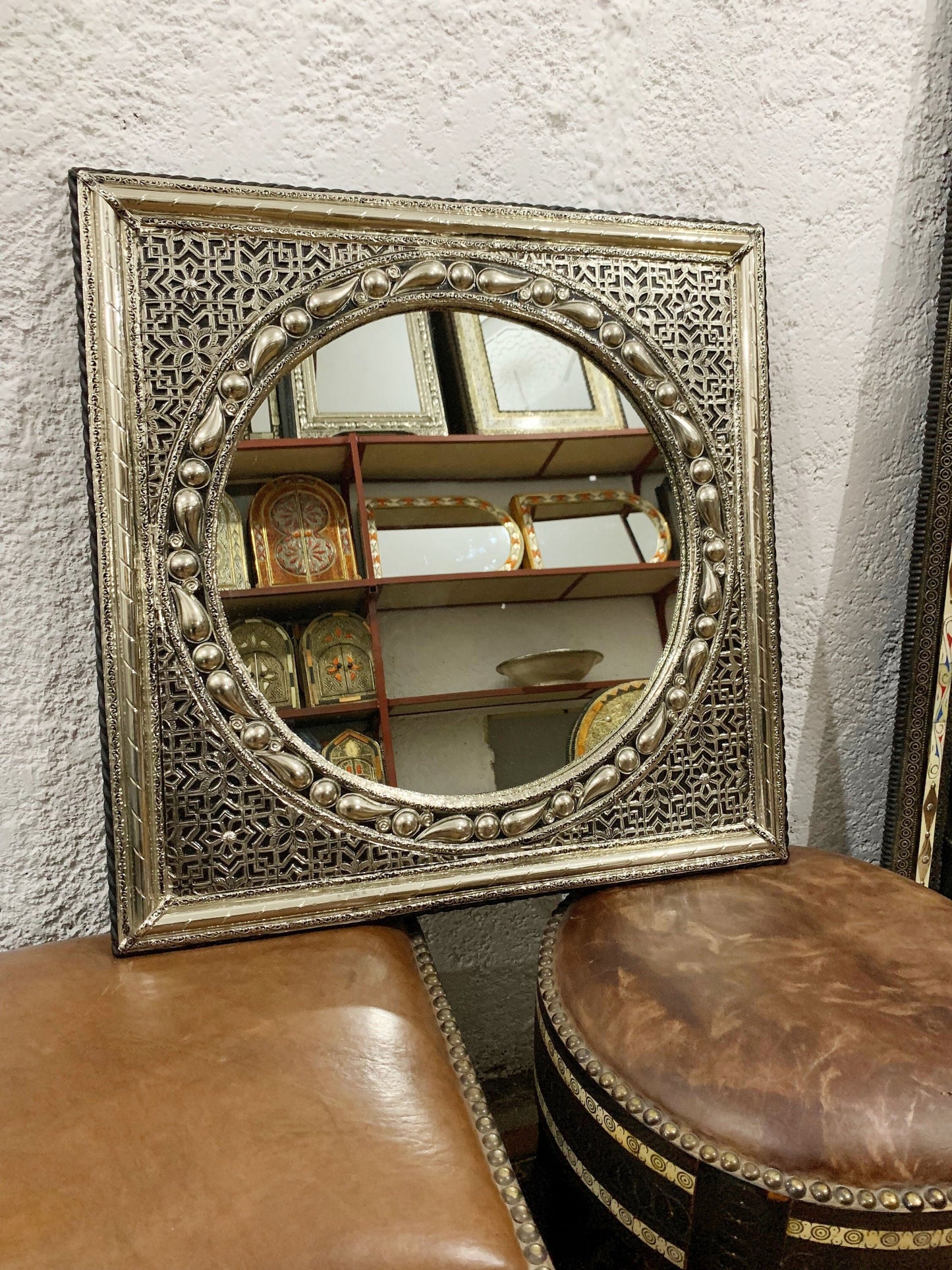 a mirror sitting on top of a table next to a stool