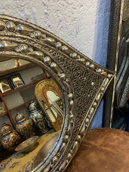 a mirror sitting on top of a table next to a chair