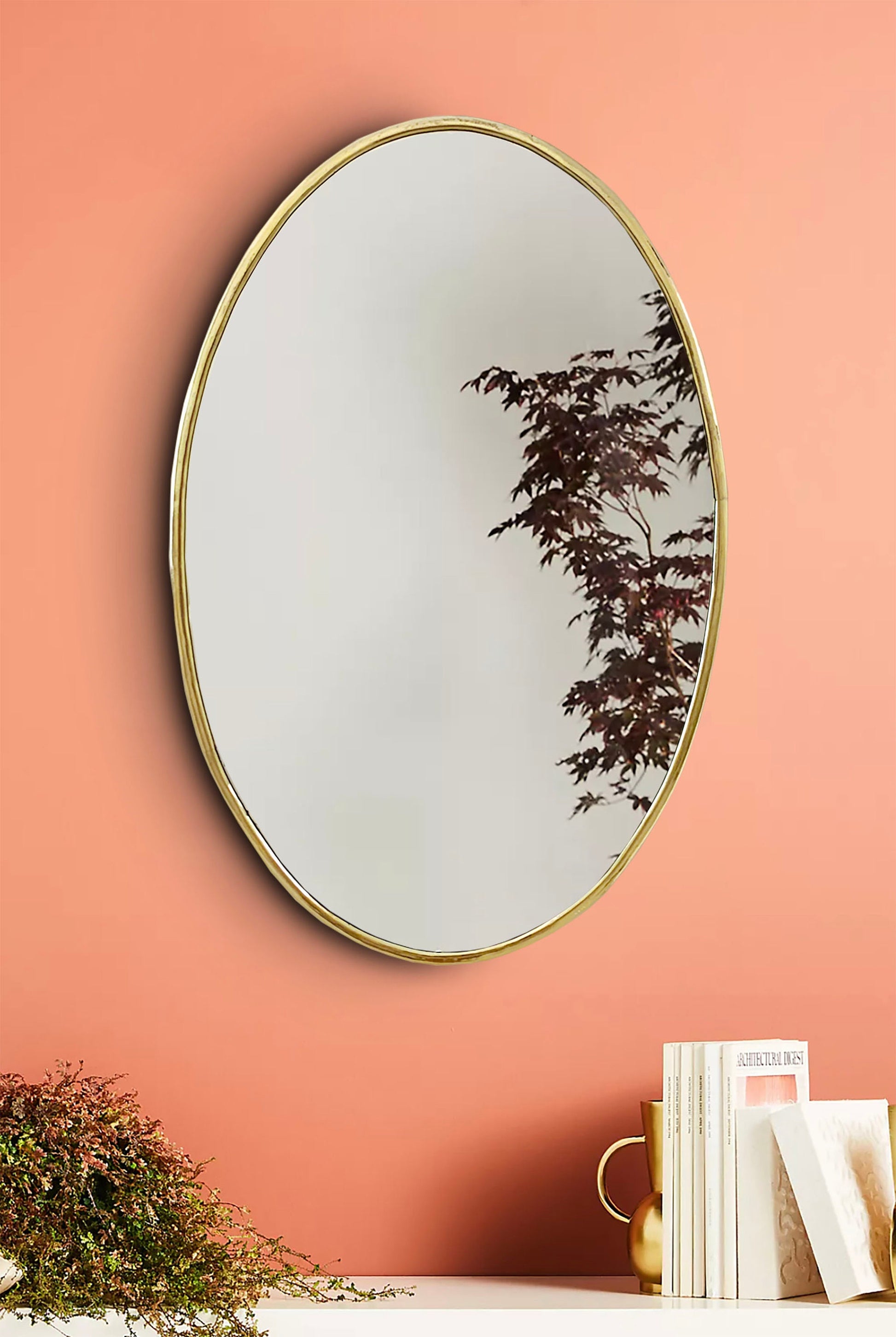 a mirror on a wall above a book shelf