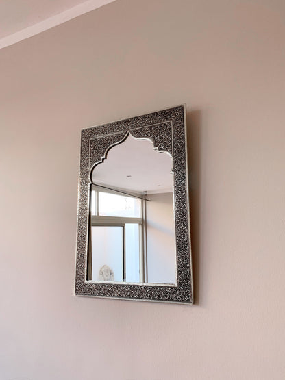 a mirror hanging on the side of a wall