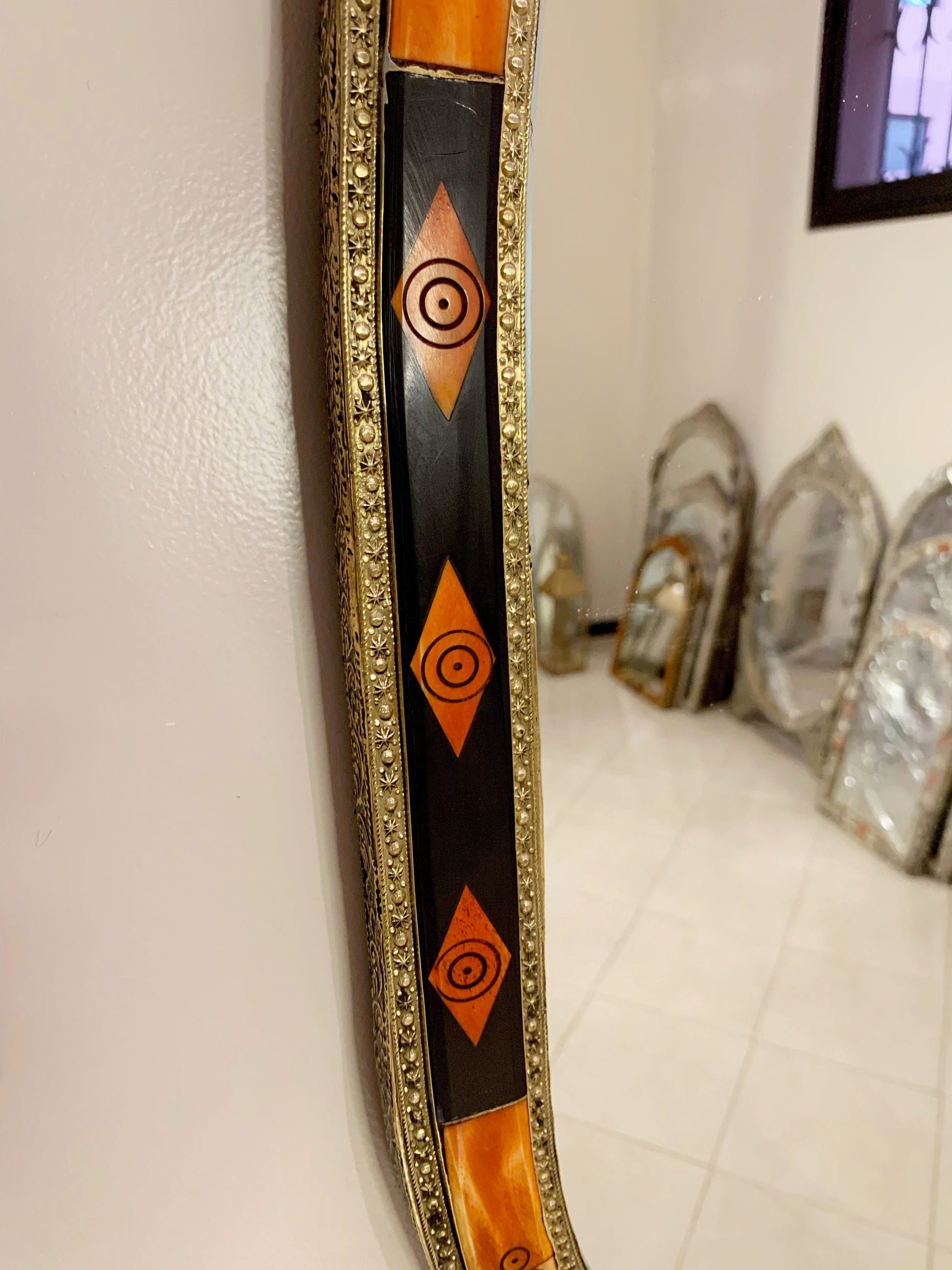 a mirror hanging on a wall next to a tiled floor