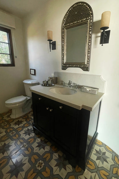 a bathroom with a sink, toilet and mirror