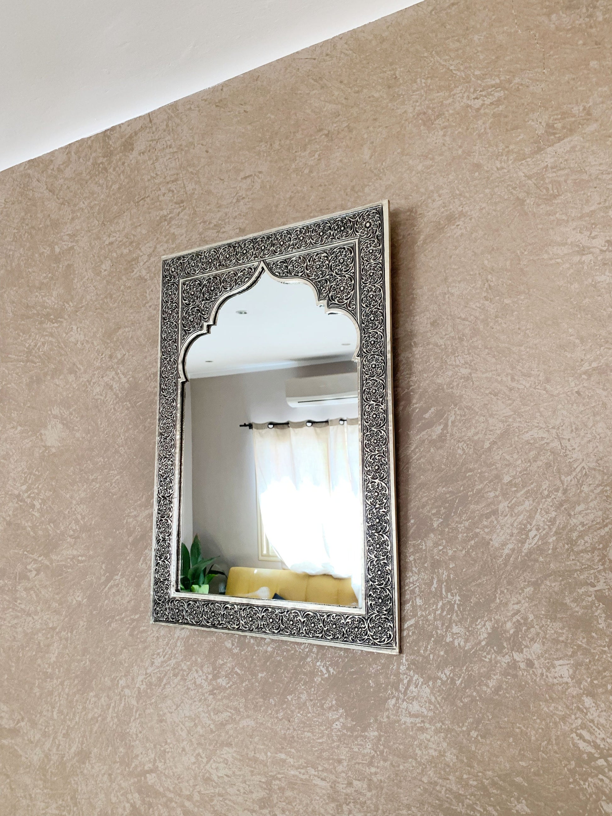 a mirror hanging on the wall above a couch