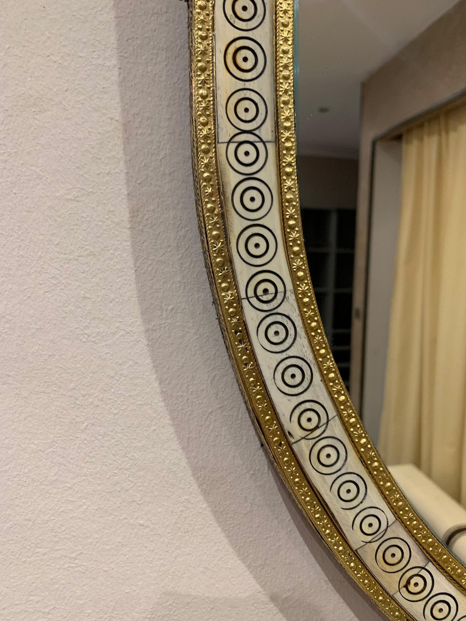 a mirror hanging on a wall next to a window