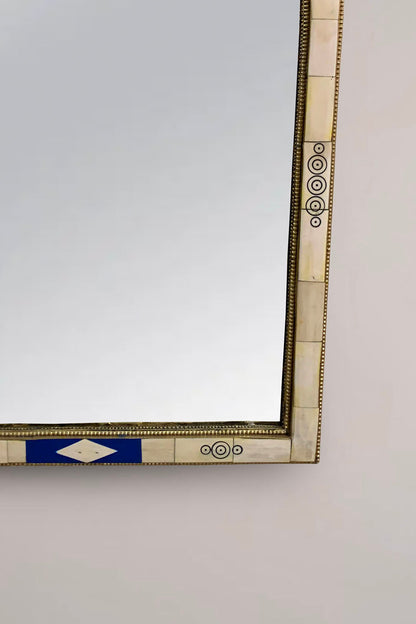 a mirror on a wall with a blue and white border