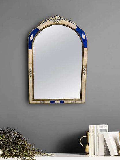 a mirror hanging on a wall next to a book shelf