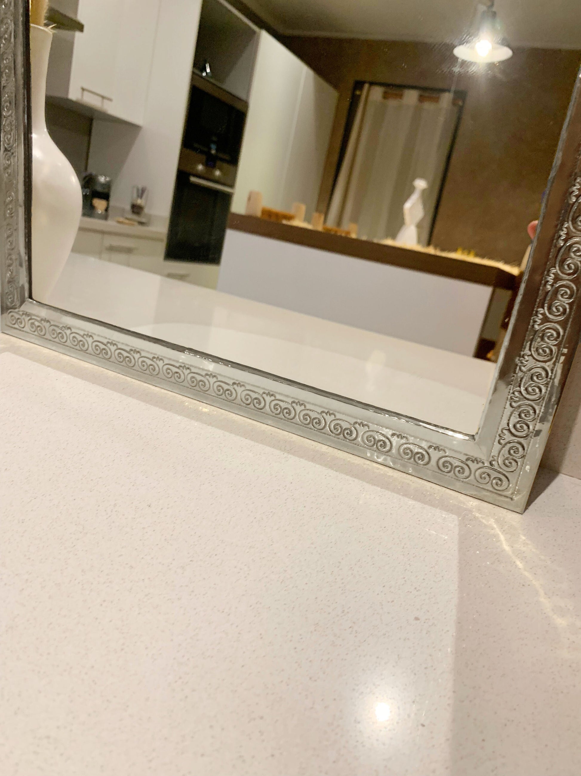 a bathroom mirror sitting on top of a counter