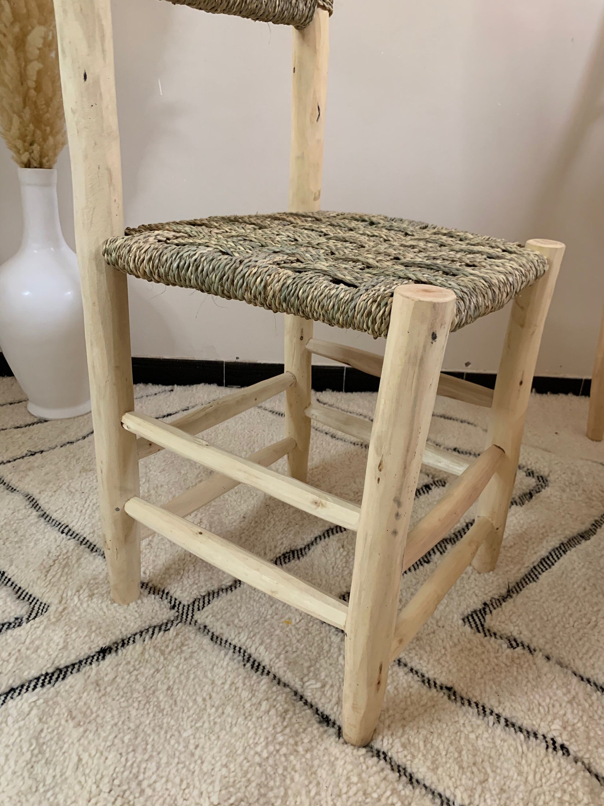 a wooden chair sitting on top of a rug