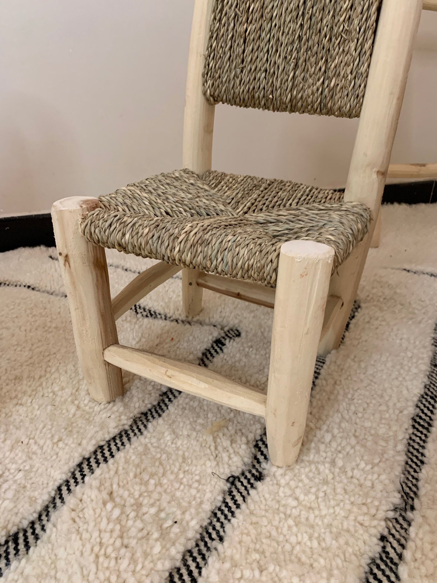 a wooden chair sitting on top of a rug