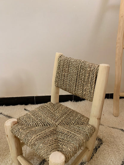 a wooden chair with a woven seat on a rug