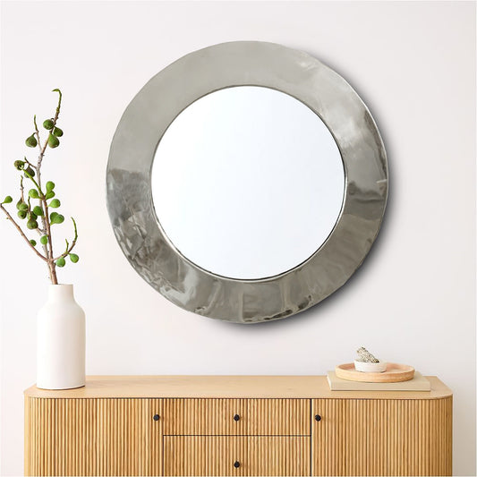 a round mirror sitting on top of a wooden dresser