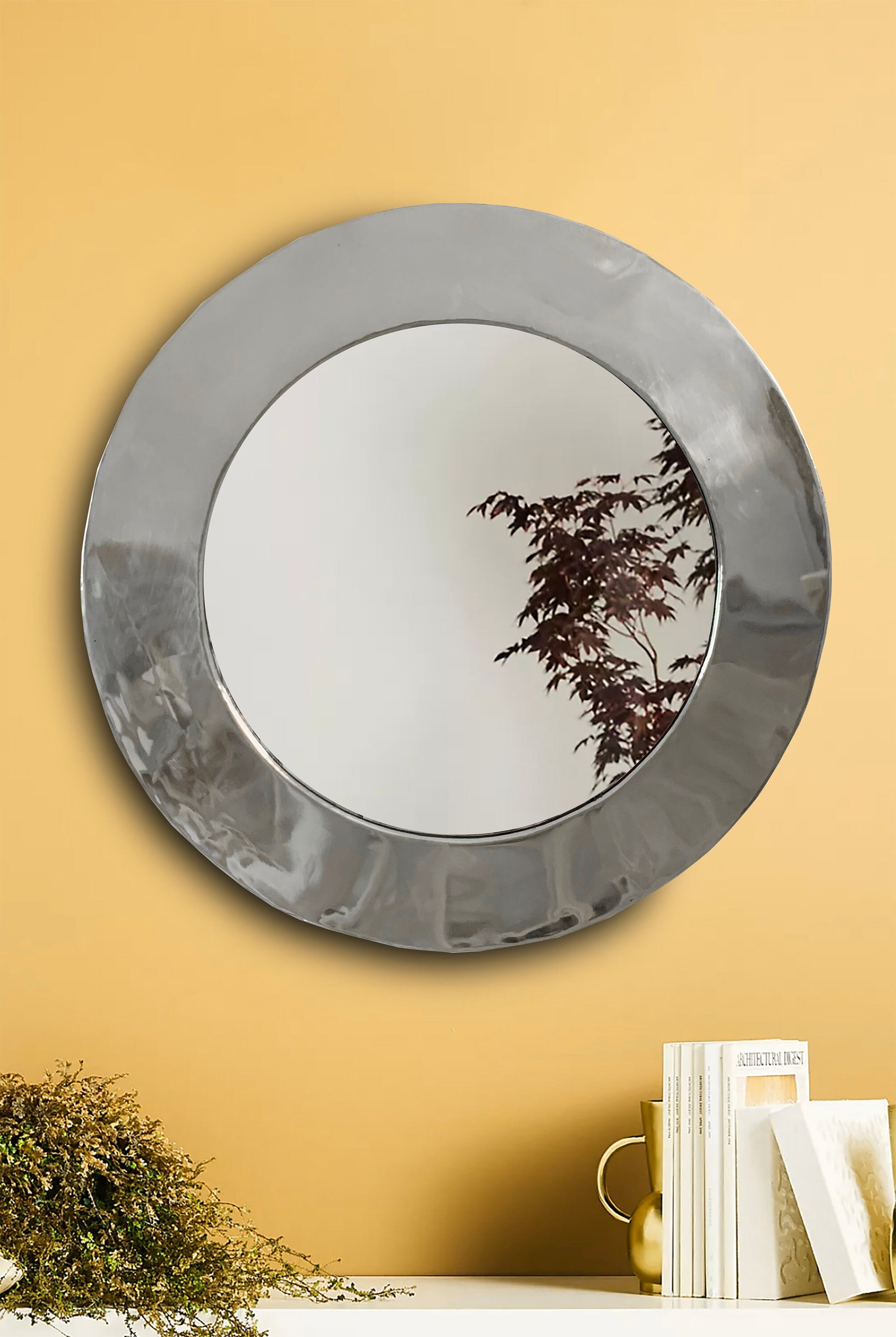 a mirror on a wall reflecting a tree