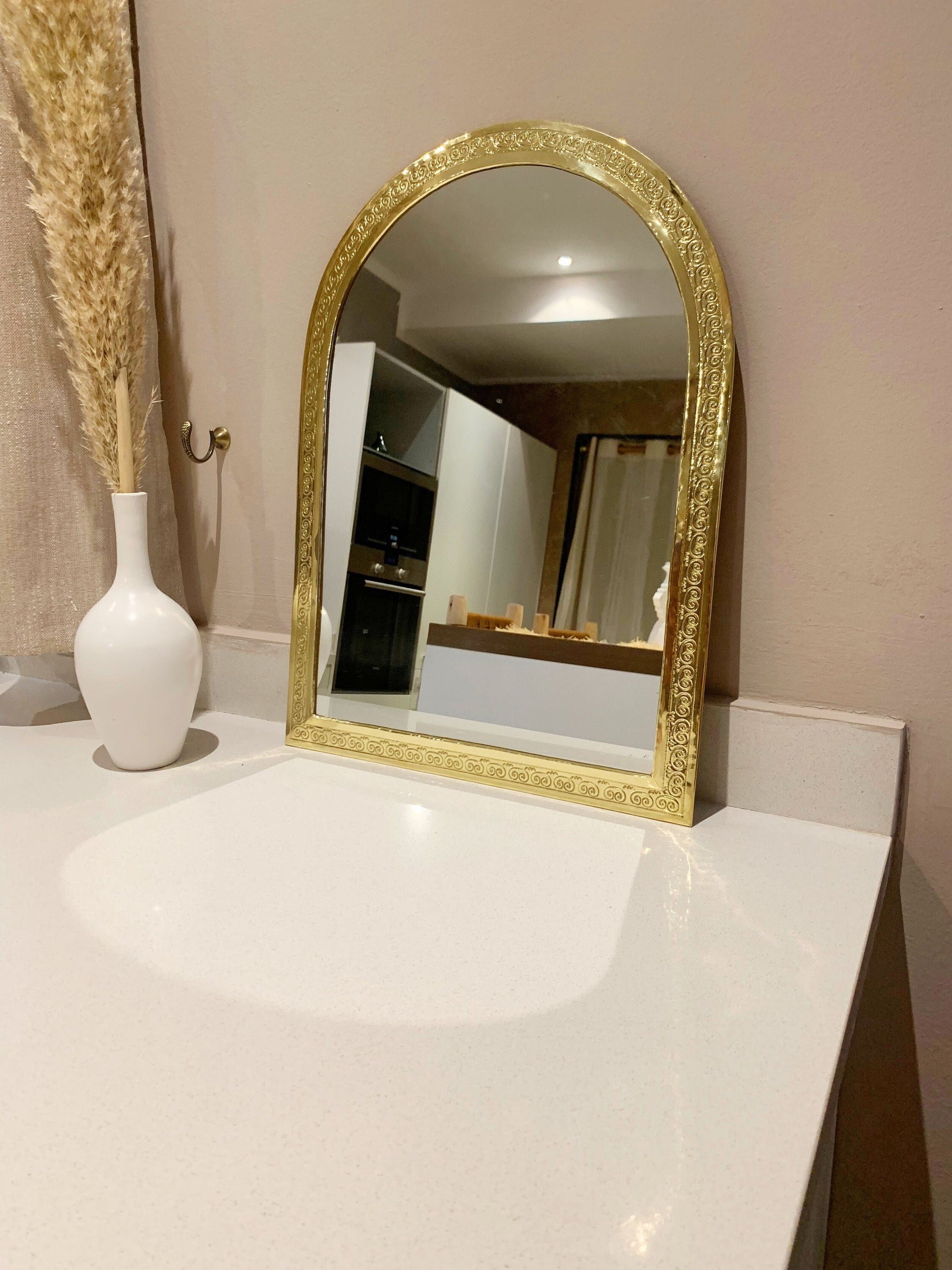 a white vase sitting on top of a white counter