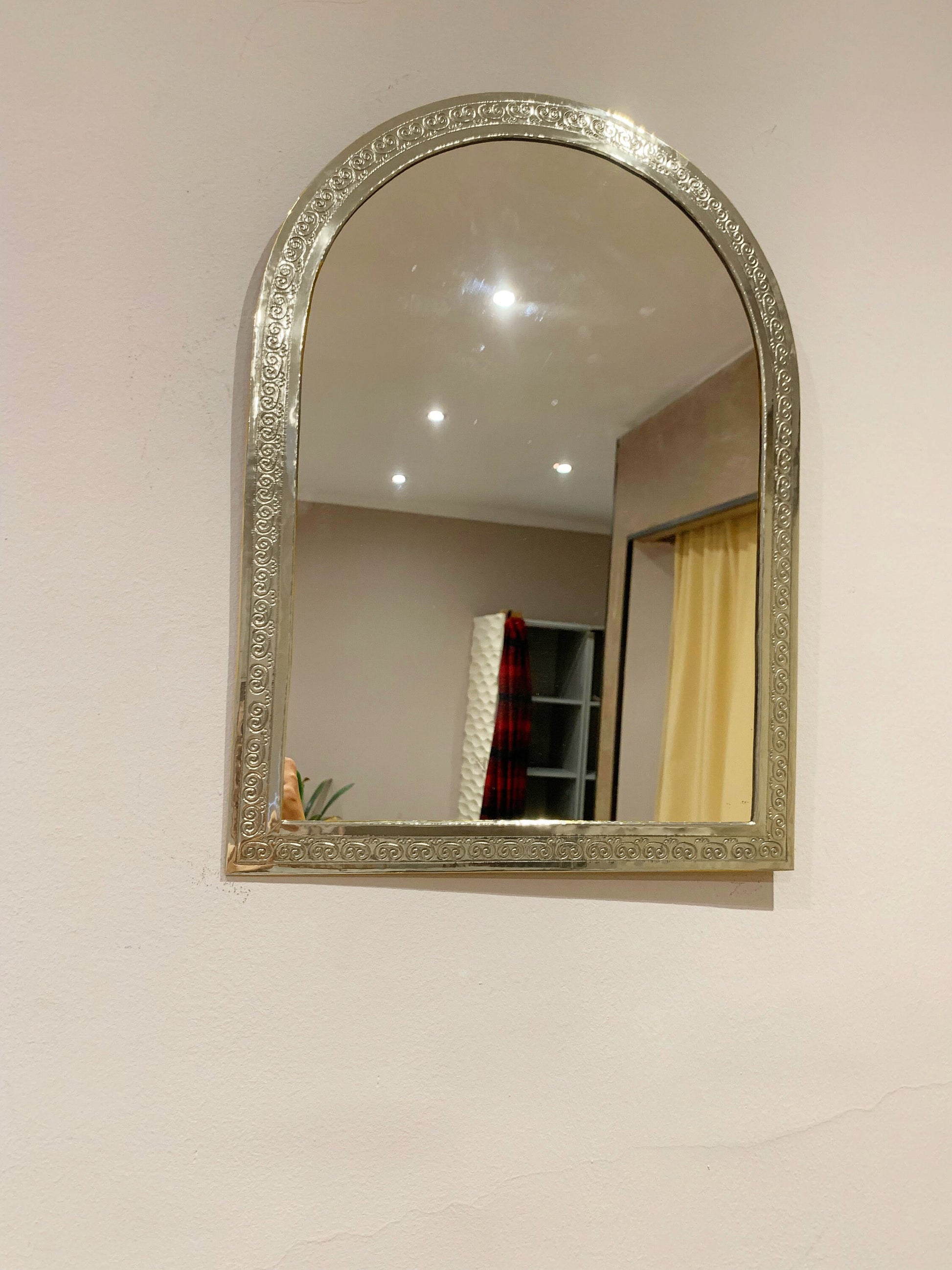 a mirror hanging on the side of a wall