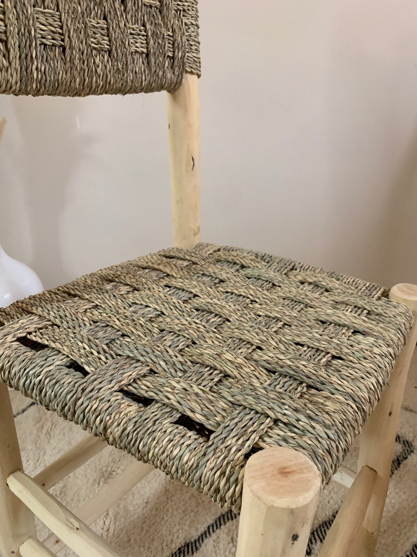 a woven seat on a wooden rocking chair