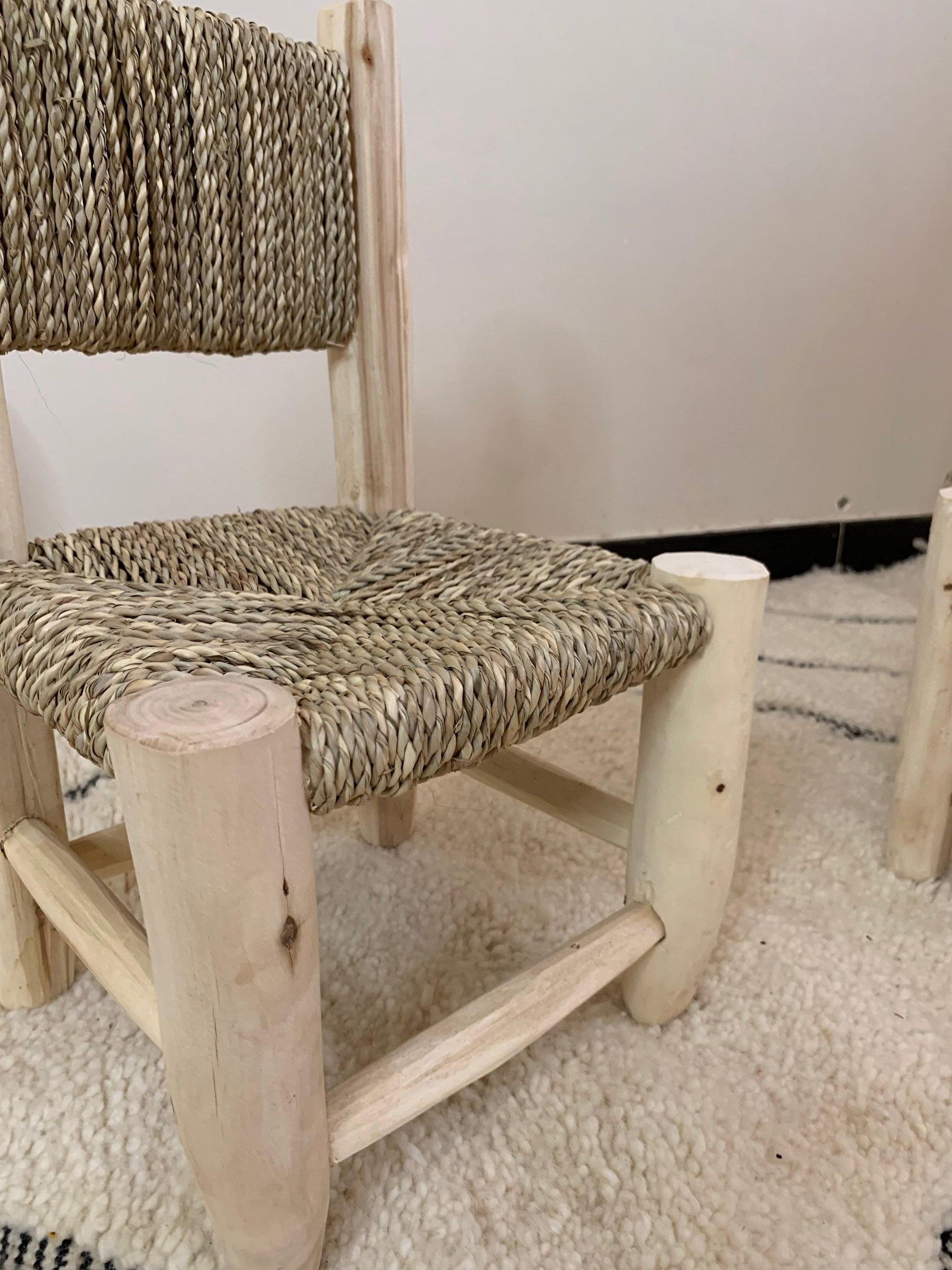 a wooden chair with rope on the back of it