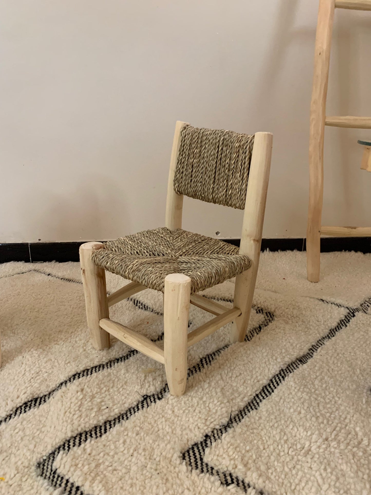 a wooden chair sitting on top of a white rug