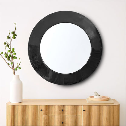 a round mirror on a wall above a dresser