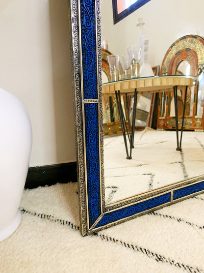 a mirror sitting on top of a rug next to a table