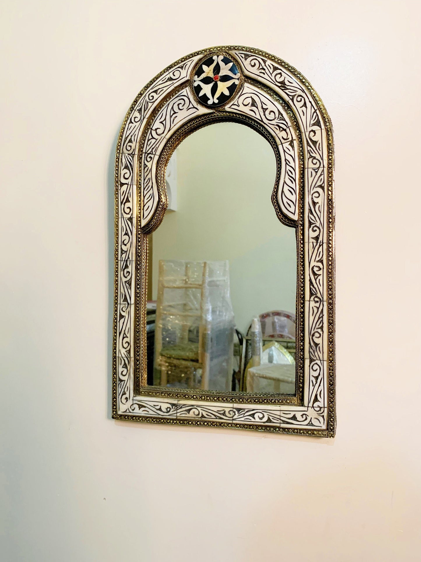 a mirror hanging on a wall next to a vase