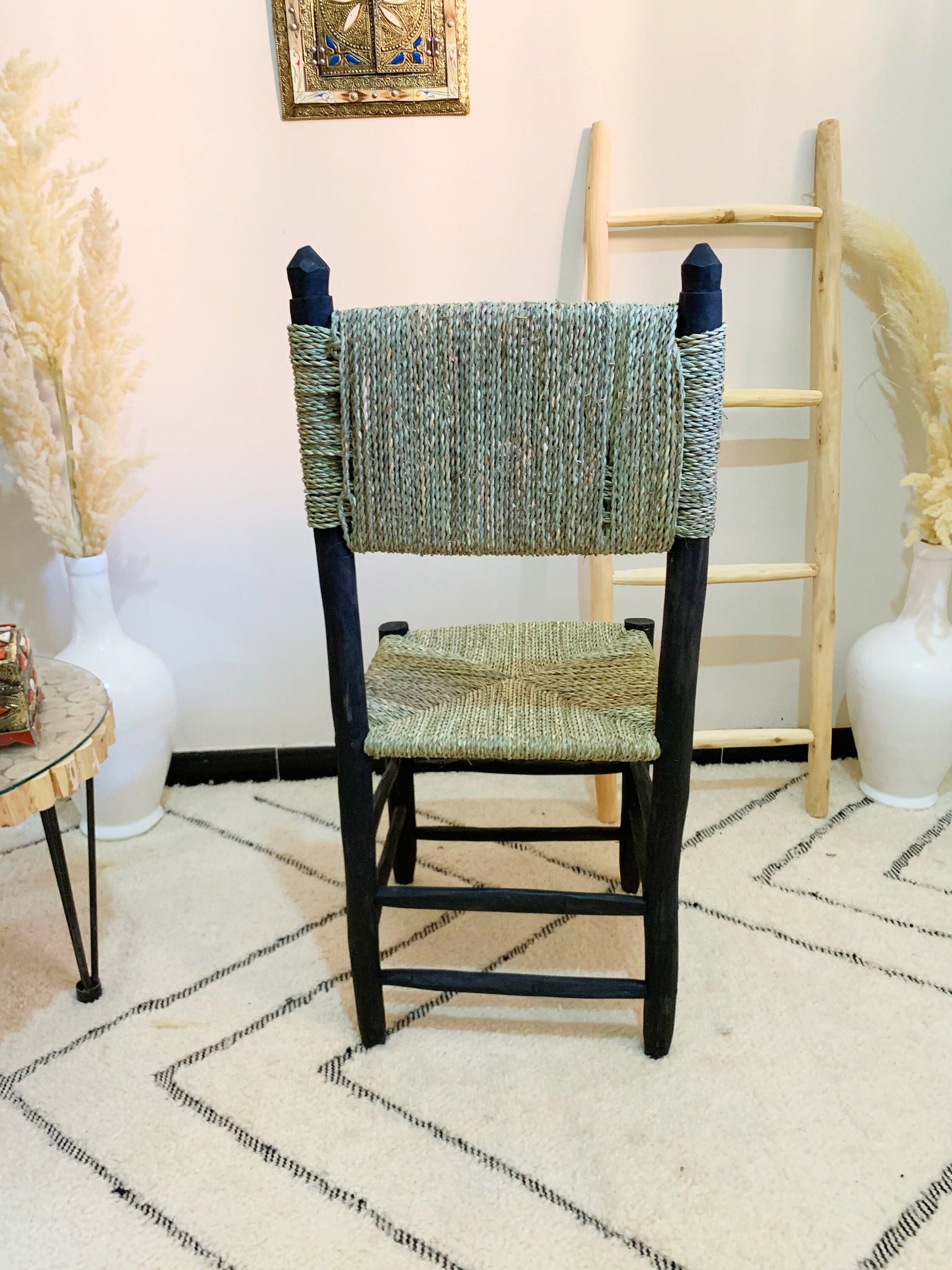 a chair sitting in a room next to a ladder