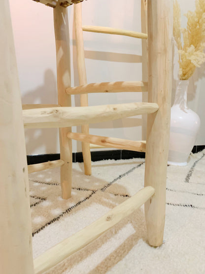 a wooden chair sitting on top of a white rug