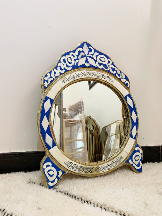 a mirror sitting on top of a rug next to a wall