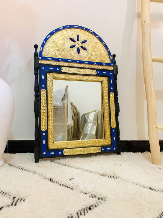 a blue and gold mirror sitting on top of a rug