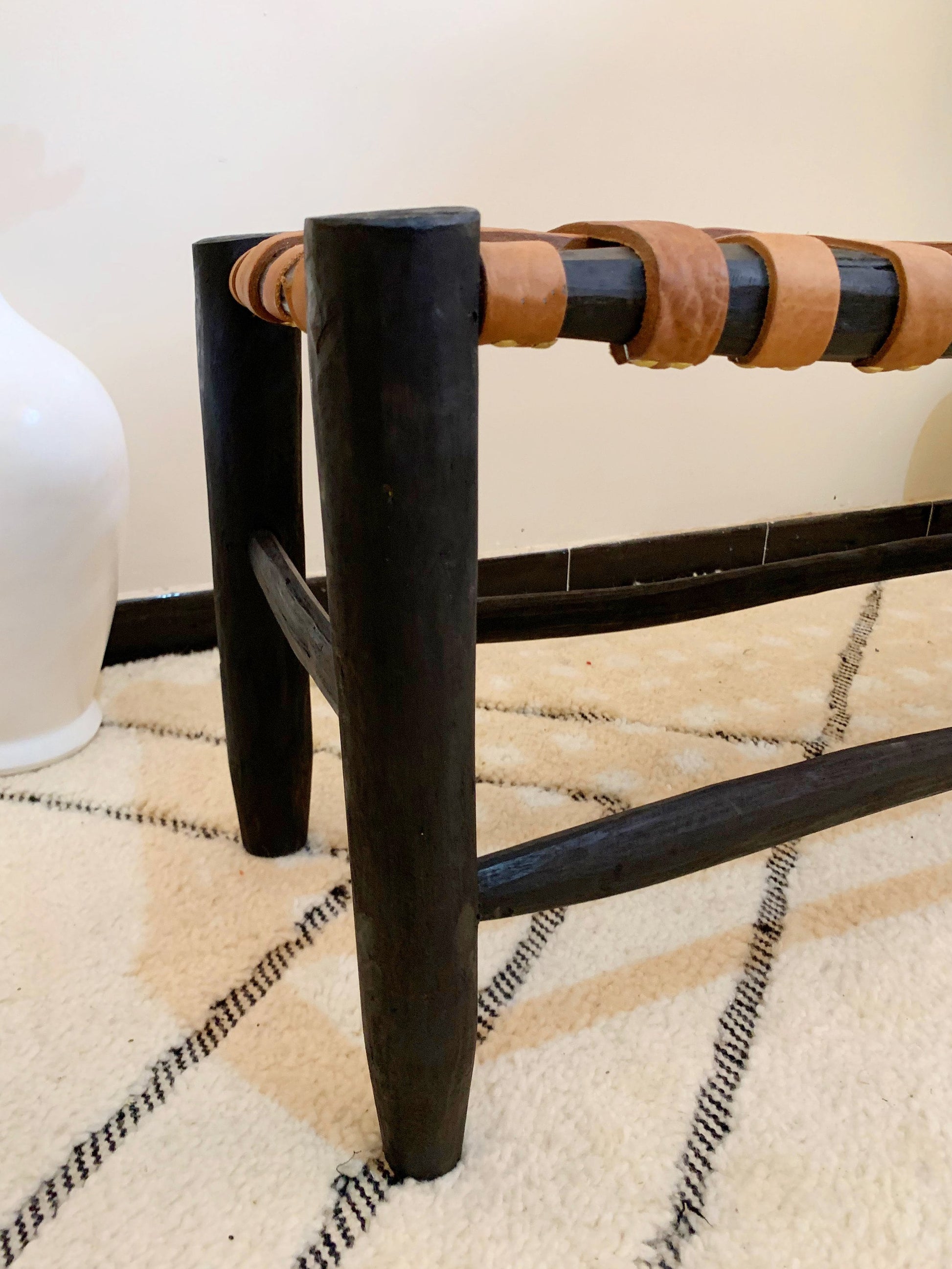 a black and brown bench sitting on top of a rug