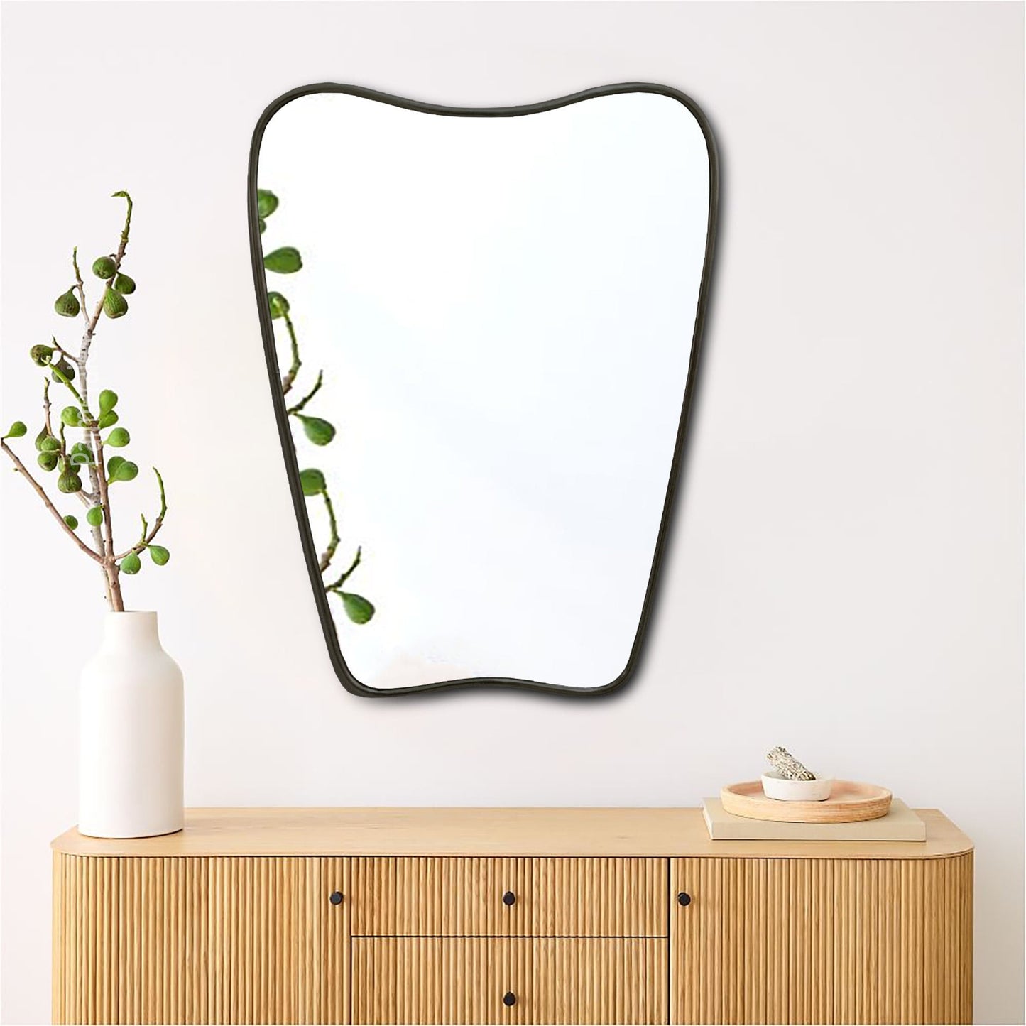 a mirror sitting on top of a wooden dresser