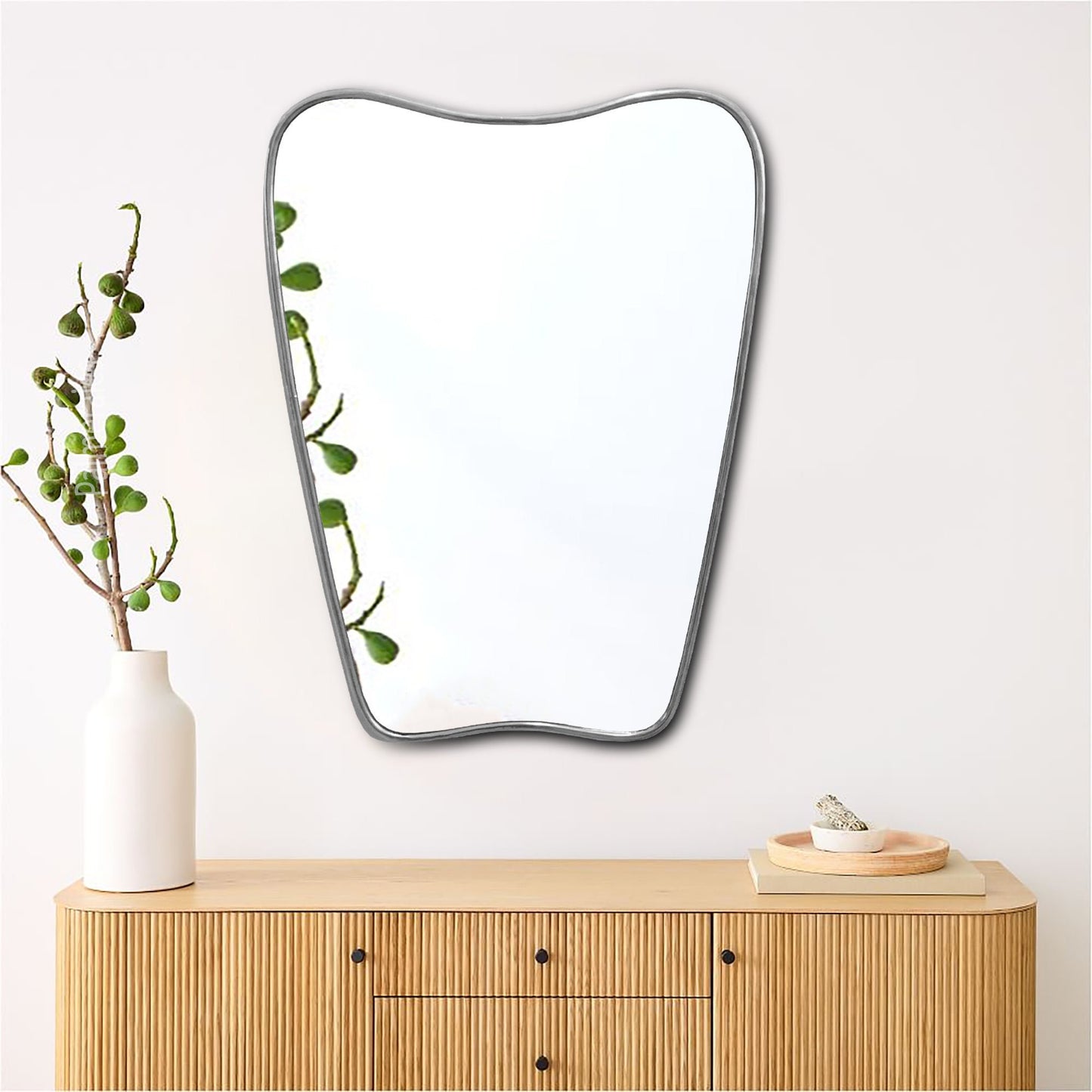 a mirror sitting on top of a wooden dresser