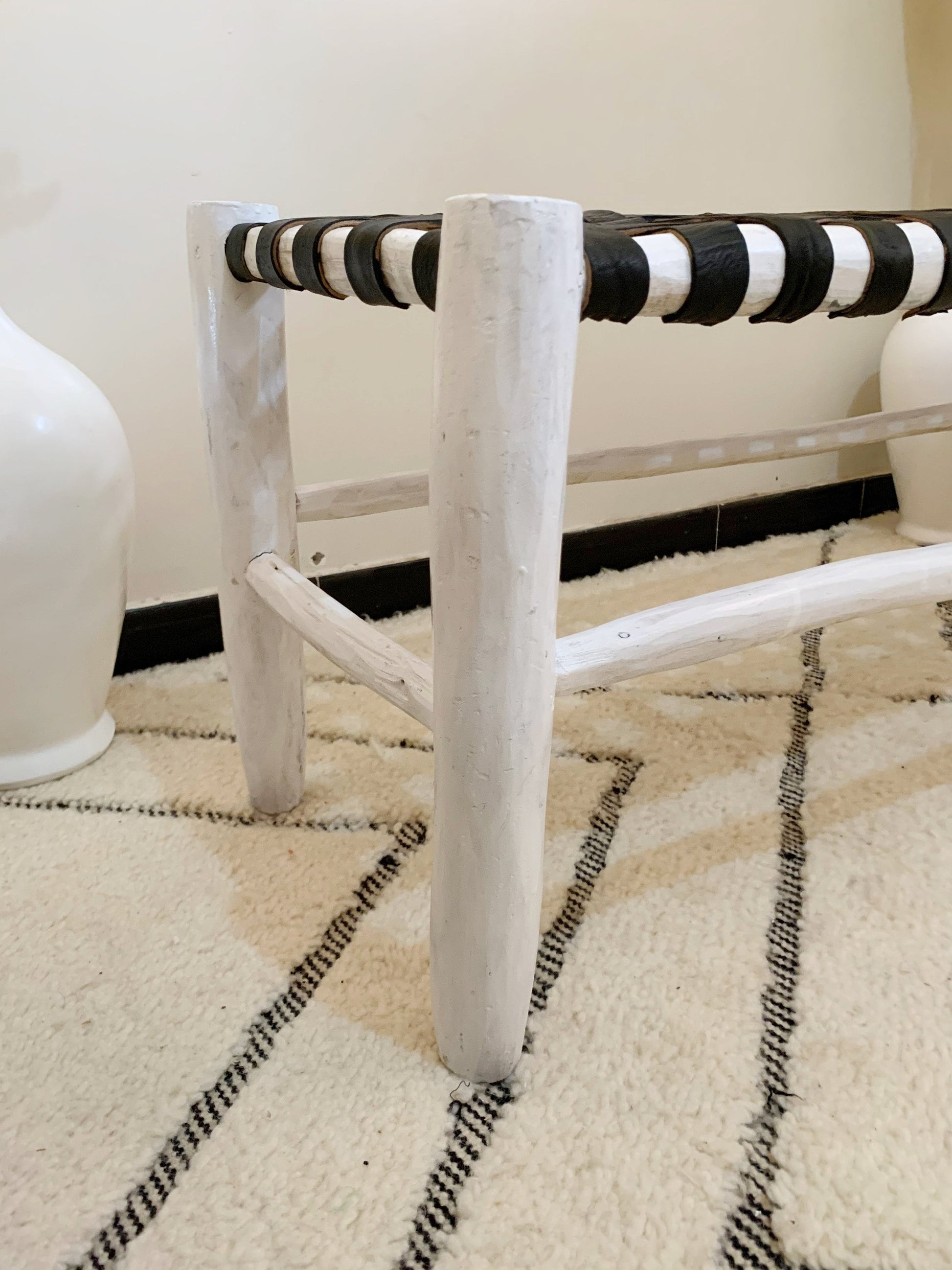 a white and black bench sitting on top of a rug