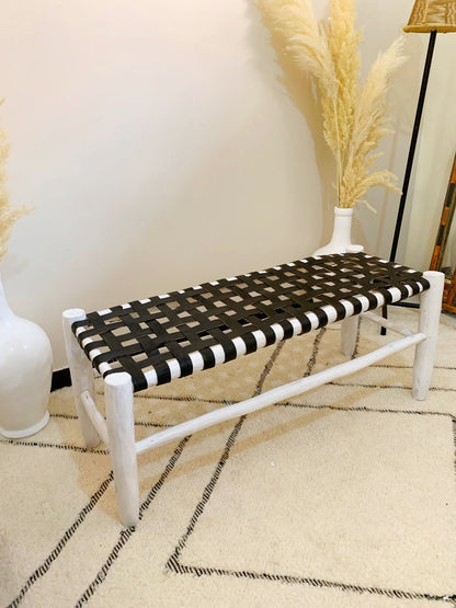 a black and white bench next to a white vase