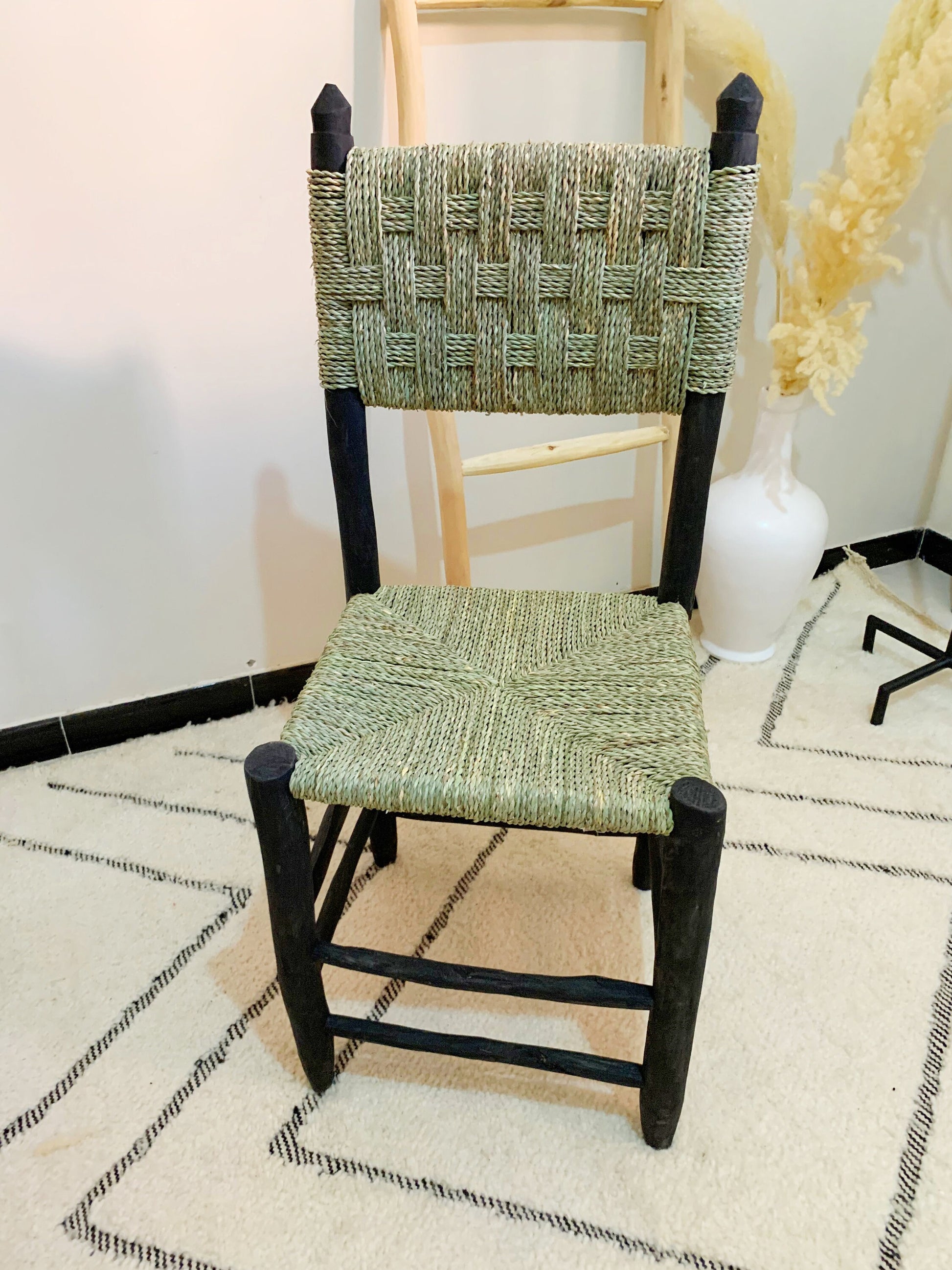 a wooden chair with a woven seat on a rug