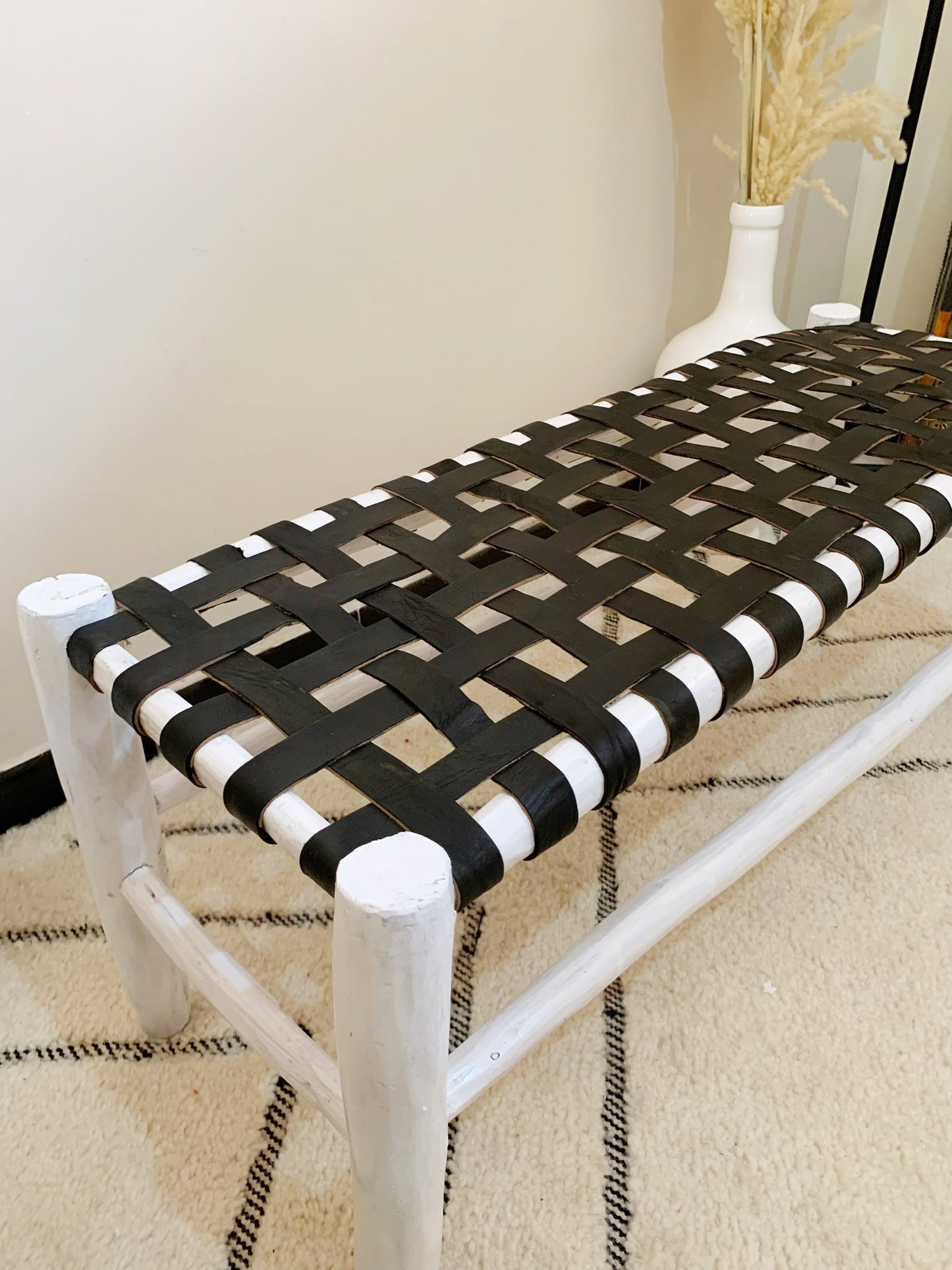 a black and white bench sitting on top of a rug