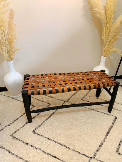 a wooden bench sitting on top of a rug next to two vases