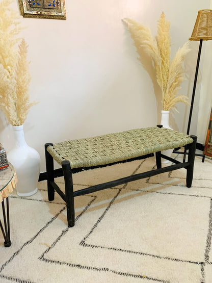 a bench sitting in a room next to two vases