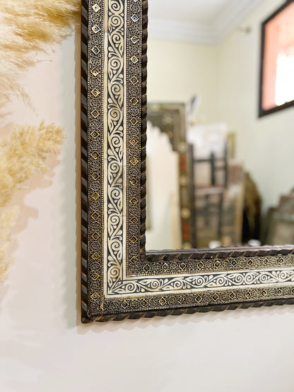 a mirror hanging on a wall next to a teddy bear