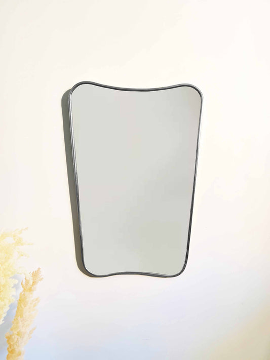 a white wall with a mirror hanging on it