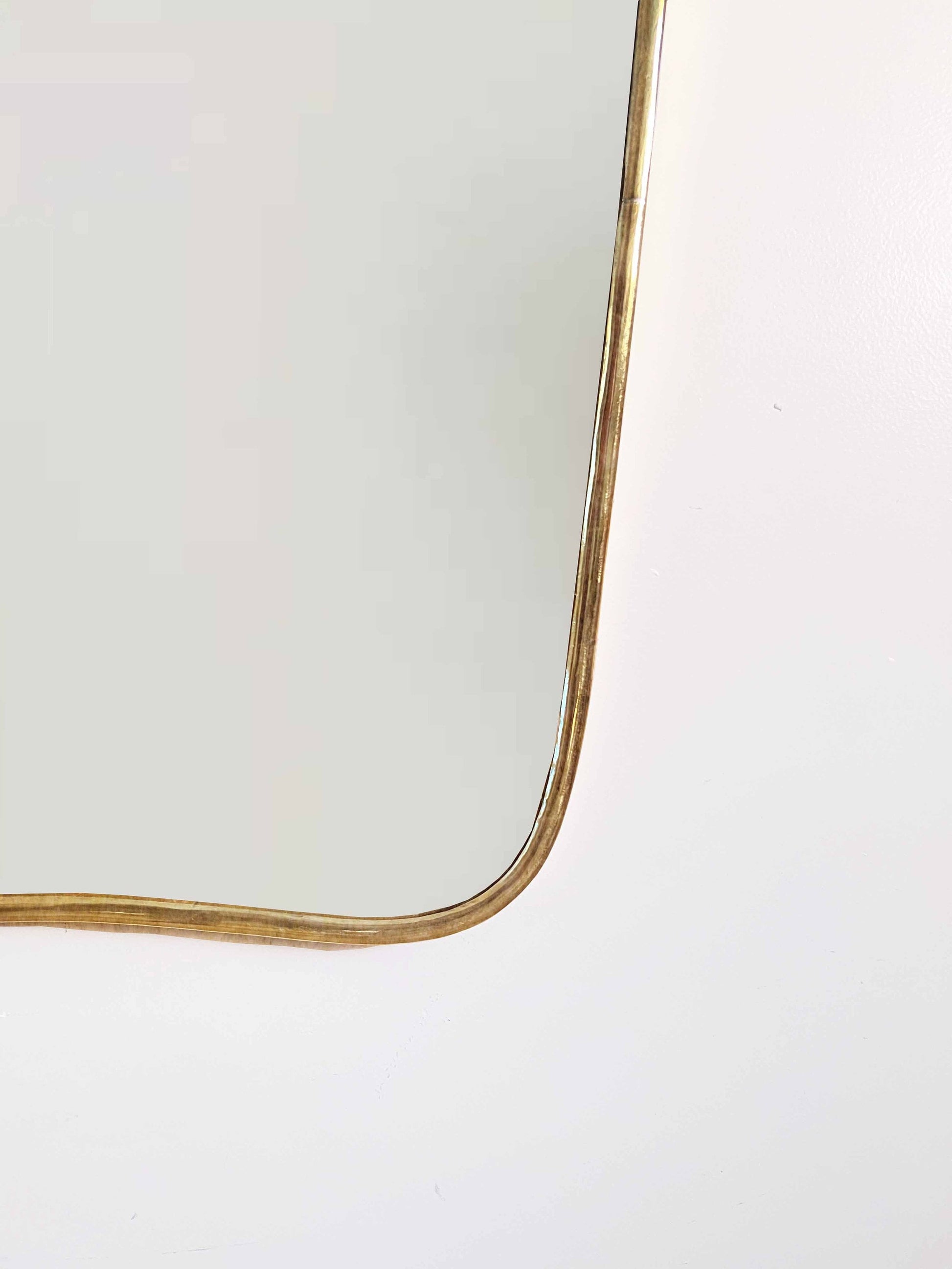 a gold framed mirror on a white wall