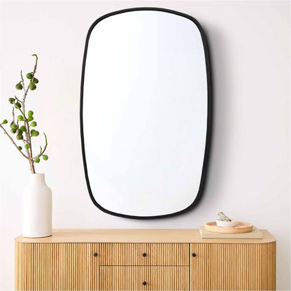 a mirror sitting on top of a wooden dresser