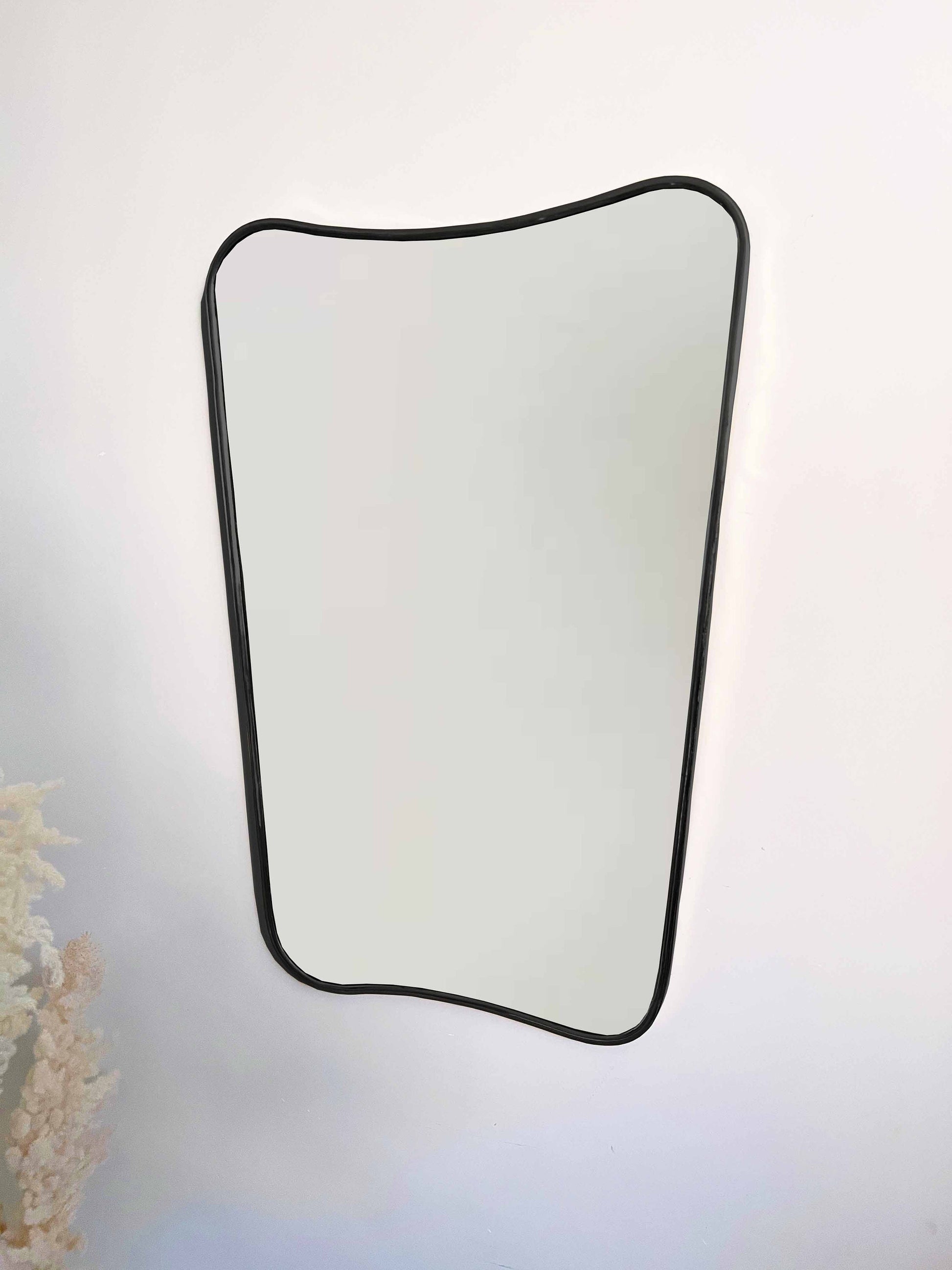 a mirror hanging on a wall next to a vase