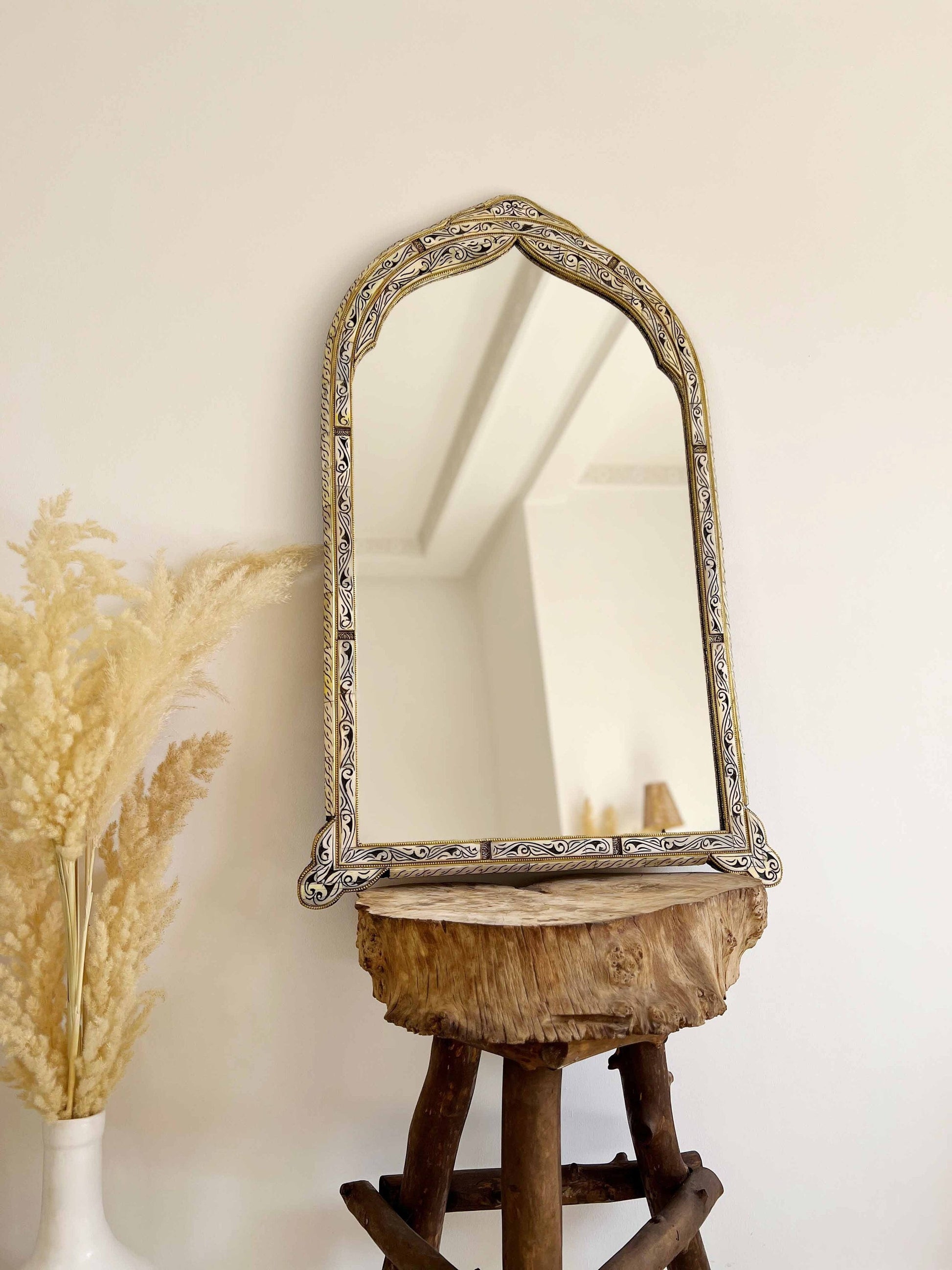 a mirror sitting on top of a wooden stool